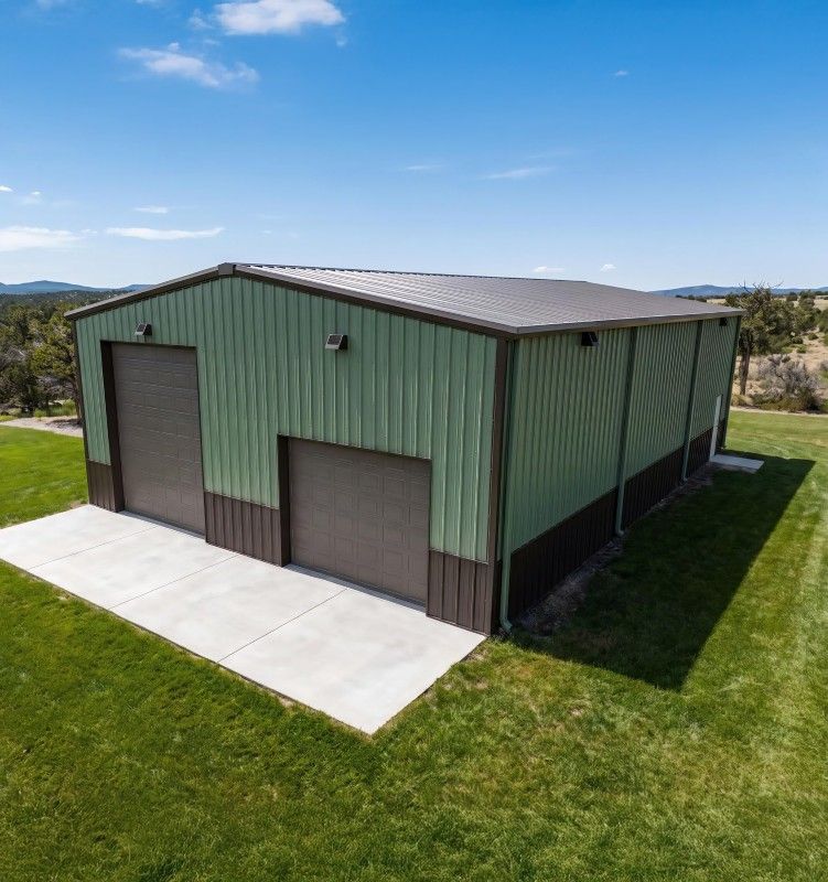 Cream pole barn garage with two overhead doors and a concrete apron